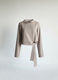 Beige long-sleeve top with a tie detail on a light gray background ishq e amore asymmetrical top 